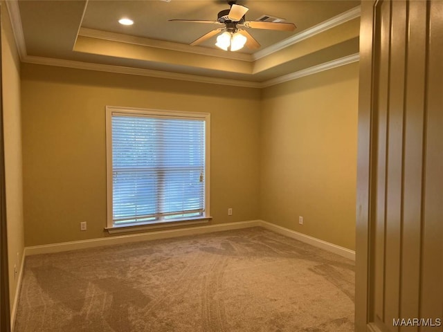 unfurnished room with a tray ceiling, ceiling fan, ornamental molding, and carpet
