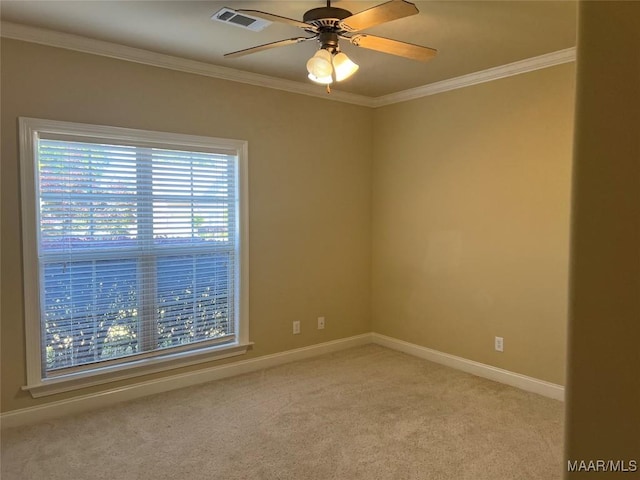 spare room with visible vents, baseboards, ornamental molding, a ceiling fan, and light colored carpet