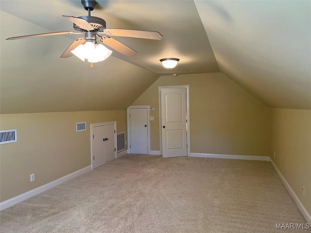 bonus room with visible vents, light colored carpet, and vaulted ceiling