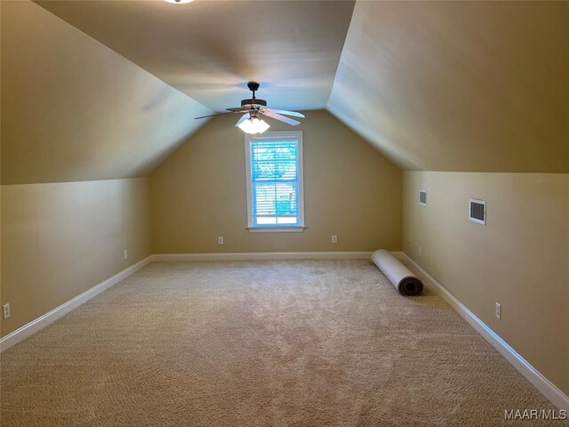 bonus room featuring ceiling fan, visible vents, light carpet, lofted ceiling, and baseboards