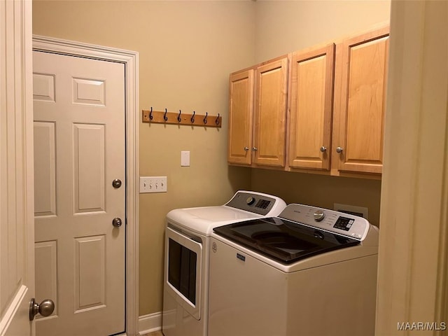 clothes washing area with washer and dryer and cabinet space
