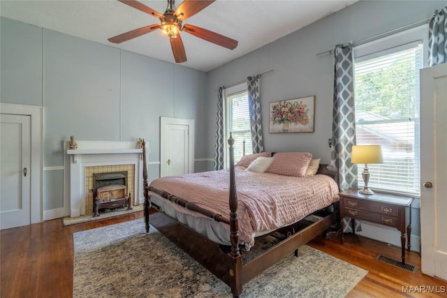 bedroom featuring visible vents, a ceiling fan, and wood finished floors
