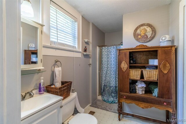 full bathroom with a textured ceiling, vanity, toilet, a shower with shower curtain, and tile patterned floors