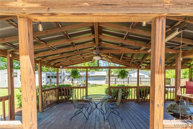 wooden deck with outdoor dining area, fence, and a water view
