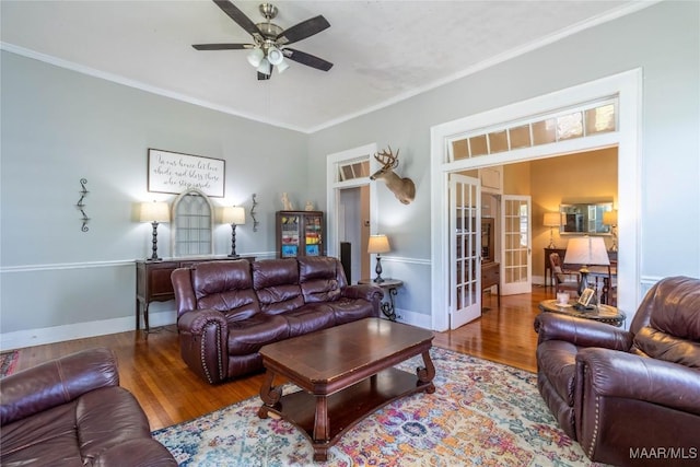 living room with baseboards, ceiling fan, crown molding, wood finished floors, and french doors