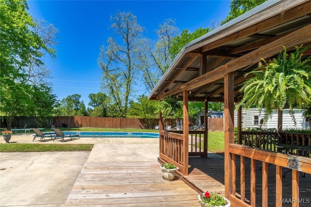 wooden deck featuring a fenced in pool, a patio area, and a fenced backyard
