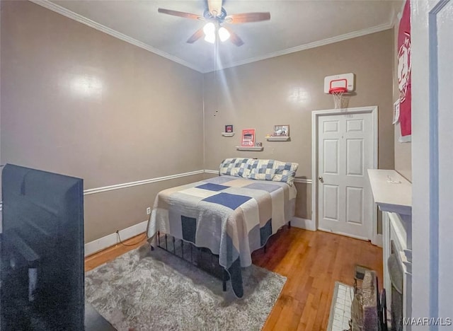 bedroom with light wood-style flooring, ceiling fan, baseboards, and ornamental molding