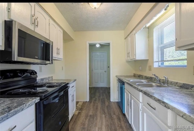 513 Gardendale Dr, Montgomery, AL 36110 - kitchen with stainless steel appliances, a sink, dark wood-type flooring, white cabinetry, and a textured ceiling
