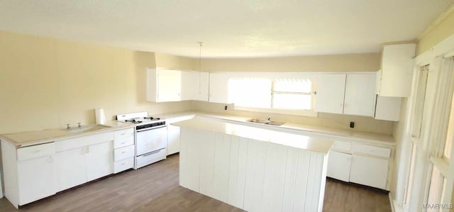 kitchen with a sink, white cabinetry, white gas range oven, and wood finished floors