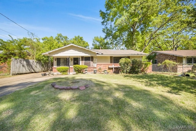 single story home with a front yard, brick siding, fence, and a porch