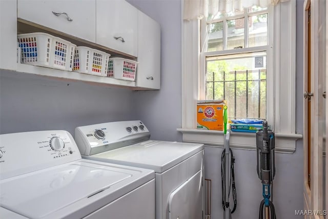 washroom featuring washing machine and dryer and cabinet space