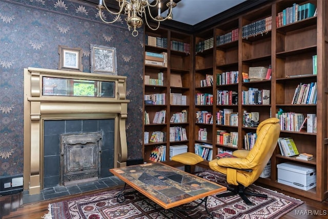 living area featuring dark wood-type flooring, wallpapered walls, and a notable chandelier