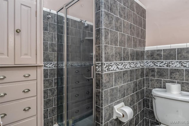 full bath with toilet, tile walls, and a stall shower