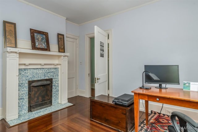 office area with crown molding, wood finished floors, and a tiled fireplace