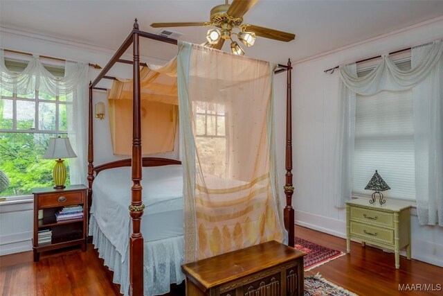 bedroom with visible vents, multiple windows, and wood finished floors