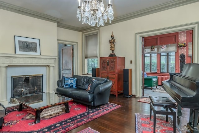 living area featuring dark wood-style flooring, ornamental molding, an inviting chandelier, and a fireplace