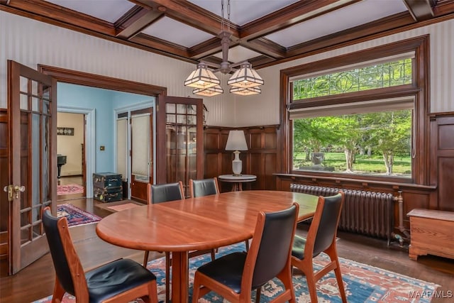 dining room with radiator heating unit, french doors, beam ceiling, and wood finished floors