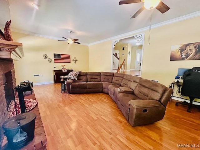 living room featuring light wood-style flooring, ornamental molding, and ceiling fan