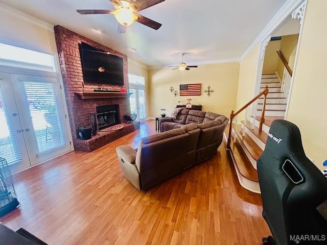 living room featuring ornamental molding, a ceiling fan, wood finished floors, and stairs