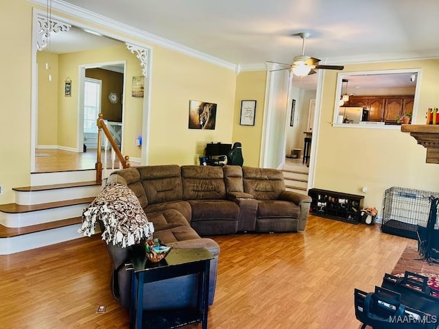 living area featuring ornamental molding, baseboards, a ceiling fan, and wood finished floors