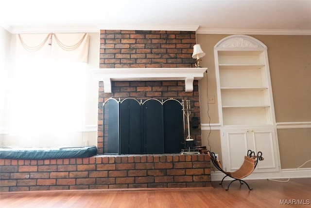 interior details with crown molding, built in features, a brick fireplace, and wood finished floors