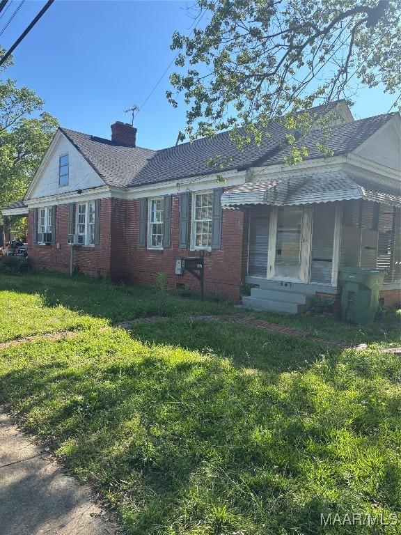305 Federal Dr, Montgomery, AL 36107 - view of front of home with roof with shingles, a front yard, brick siding, and a chimney