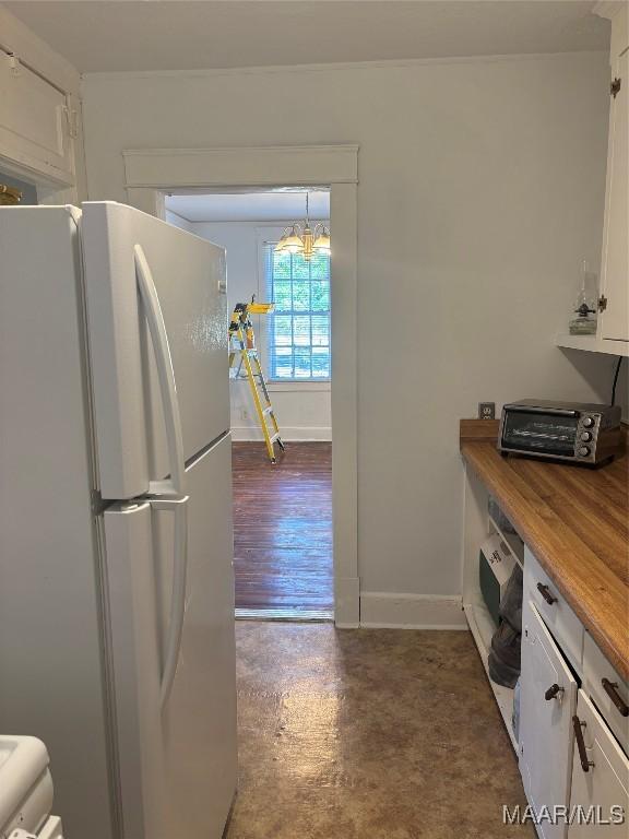 305 Federal Dr, Montgomery, AL 36107 - kitchen featuring white cabinets, baseboards, a notable chandelier, freestanding refrigerator, and a toaster