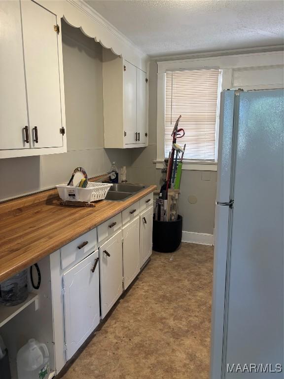 305 Federal Dr, Montgomery, AL 36107 - kitchen featuring baseboards, white cabinetry, freestanding refrigerator, and light floors