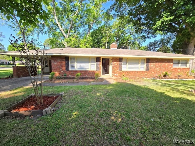 ranch-style house featuring a chimney, an attached carport, a front yard, and brick siding