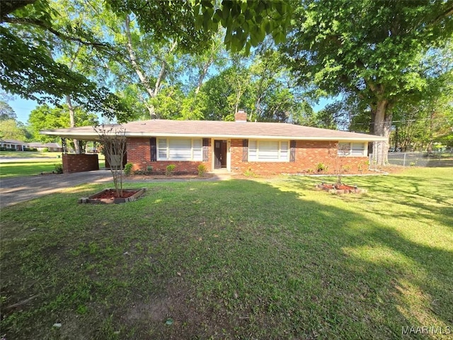 ranch-style house with a chimney, a front lawn, aphalt driveway, an attached carport, and fence