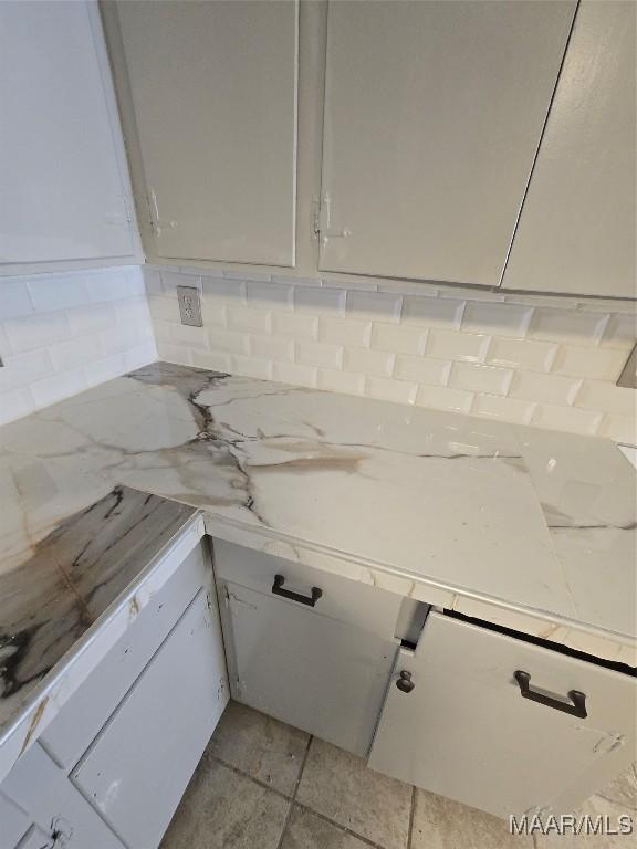 interior space featuring backsplash and white cabinets