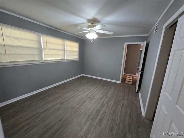 unfurnished bedroom with dark wood finished floors, baseboards, visible vents, ceiling fan, and crown molding