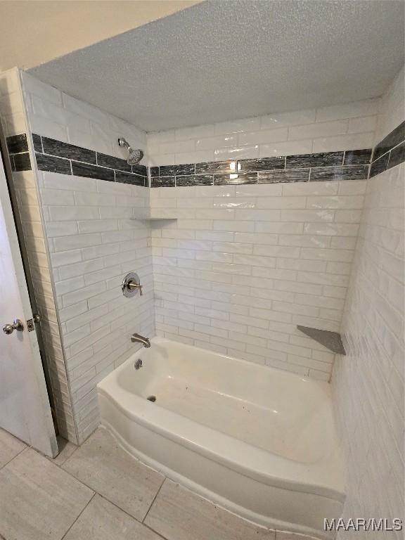 bathroom featuring tile patterned floors, a textured ceiling, and tub / shower combination