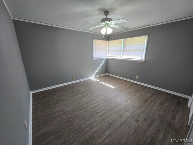spare room with dark wood-type flooring, ceiling fan, and crown molding
