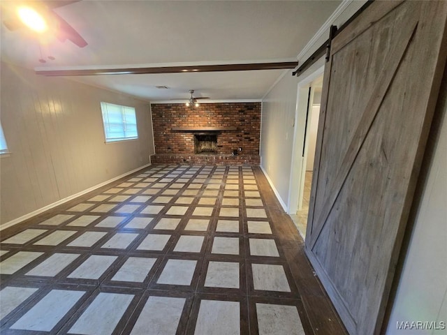 unfurnished living room with a barn door, baseboards, a ceiling fan, and a fireplace