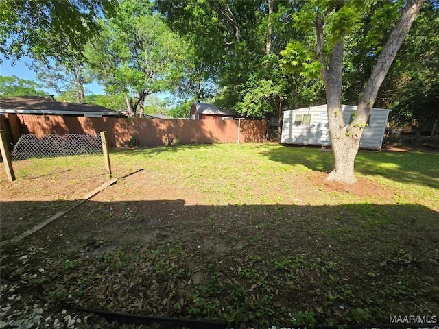 view of yard with fence, an outdoor structure, and a shed