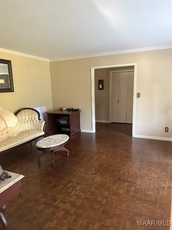 living area featuring baseboards and ornamental molding