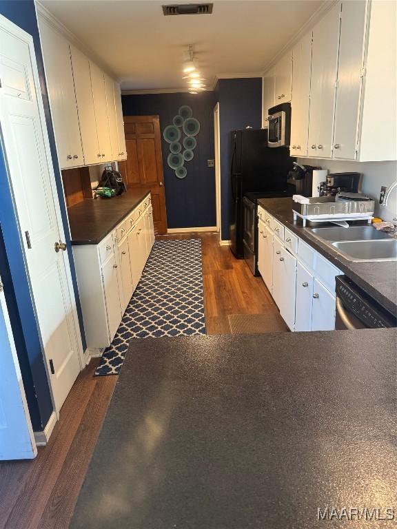 kitchen featuring dark countertops, white cabinetry, dark wood-style floors, and stainless steel appliances