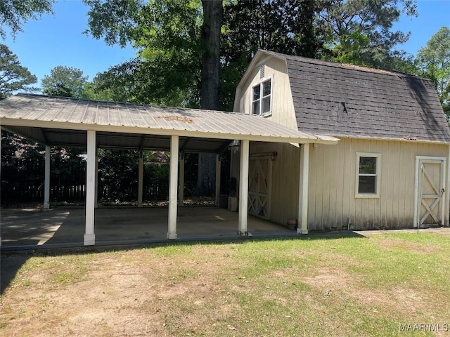exterior space featuring a gambrel roof, a carport, and a yard