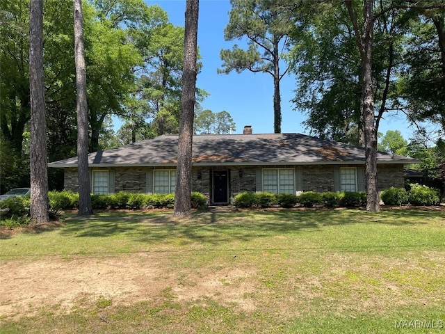 view of front of house featuring a chimney and a front lawn