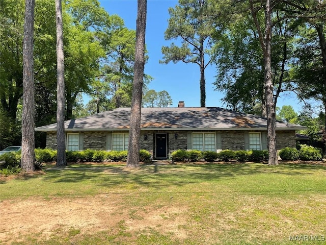 ranch-style house featuring a chimney and a front yard