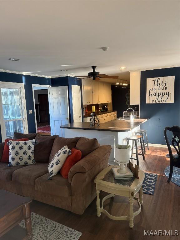 living room with baseboards, wood finished floors, and ceiling fan