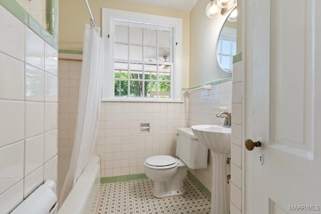 374 Rose Ln, Montgomery, AL 36104 - bathroom featuring wainscoting, toilet, shower / bathtub combination with curtain, and tile walls