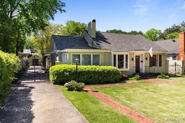 374 Rose Ln, Montgomery, AL 36104 - view of front of house featuring a chimney, a gate, a front lawn, stucco siding, and roof with shingles