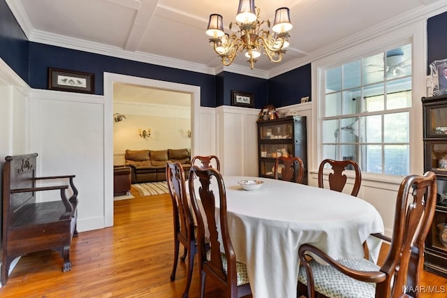 374 Rose Ln, Montgomery, AL 36104 - dining area featuring light wood finished floors, ornamental molding, a decorative wall, wainscoting, and a chandelier