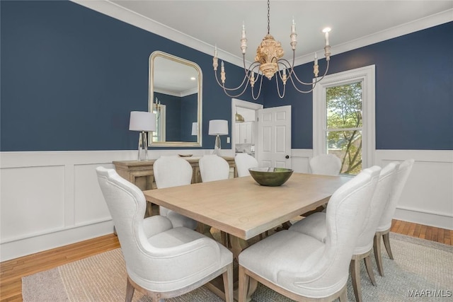 6432 Wynwood Pl, Montgomery, AL 36117 - dining area with a chandelier, a wainscoted wall, wood finished floors, crown molding, and a decorative wall