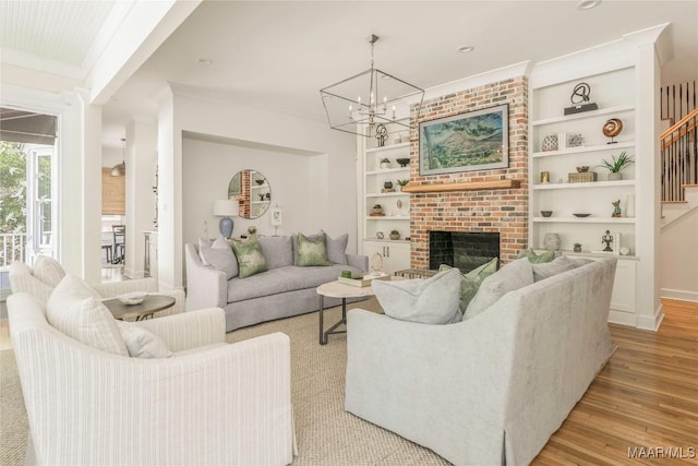 6432 Wynwood Pl, Montgomery, AL 36117 - living area with built in features, light wood-type flooring, crown molding, a brick fireplace, and a chandelier