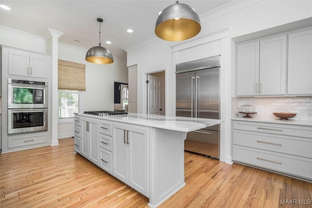 6432 Wynwood Pl, Montgomery, AL 36117 - kitchen with stainless steel appliances, ornamental molding, light countertops, pendant lighting, and light wood-type flooring