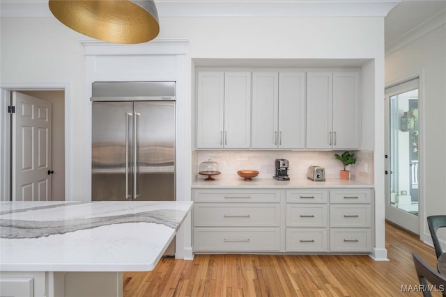 6432 Wynwood Pl, Montgomery, AL 36117 - kitchen with built in fridge, backsplash, light wood-style flooring, light stone countertops, and ornamental molding