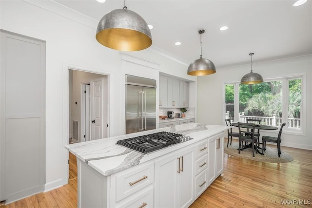 6432 Wynwood Pl, Montgomery, AL 36117 - kitchen with appliances with stainless steel finishes, crown molding, white cabinets, a center island, and light stone countertops